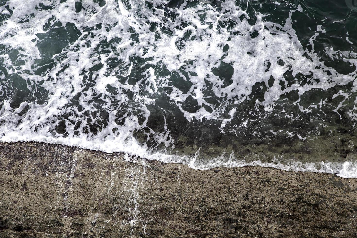 Waves crashing against the rocks photo