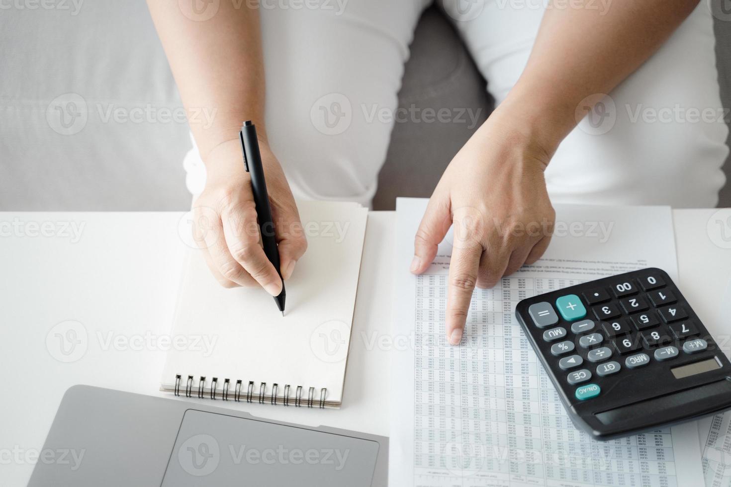 la mujer está calculando el impuesto anual con calculadora y llenando el formulario de declaración de impuestos sobre la renta individual. temporada para pagar impuestos y concepto de planificación presupuestaria. foto