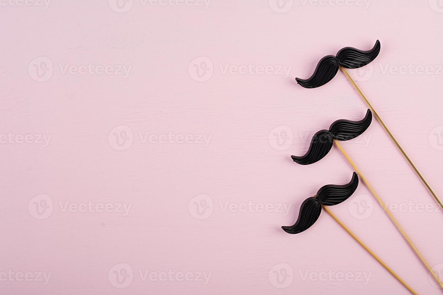 Fake black mustaches in stick. Happy Fathers day. Background of fathers day. Top view. Flat lay. photo