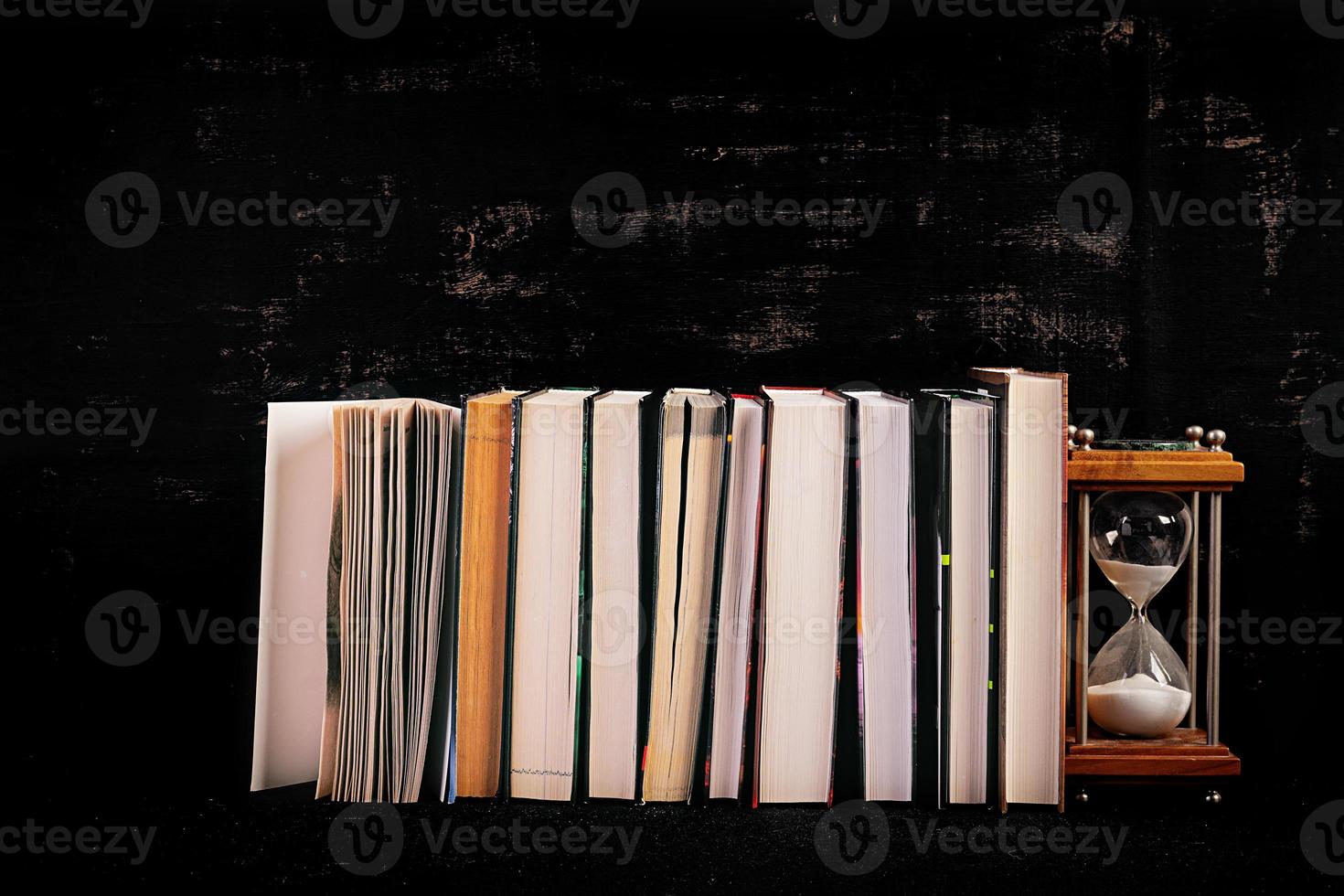 Stack of different books on dark background. Knowledge concept. photo