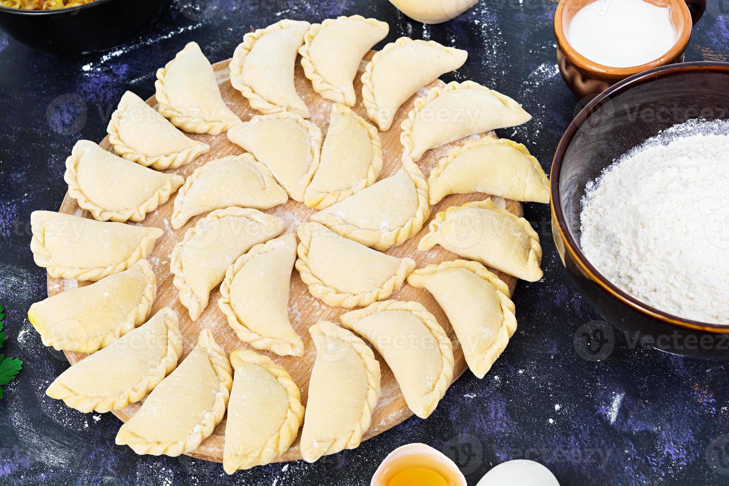 Delicious dumplings with cabbage on dark background photo