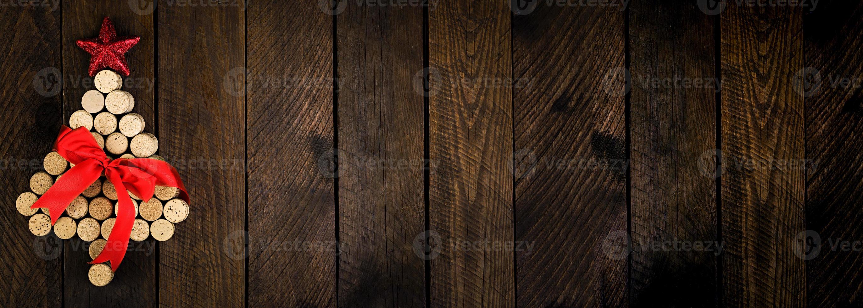 Christmas tree made of wine corks on wooden background. Mockup postcard with Christmas tree and copy space for text. Top view. Banner. photo