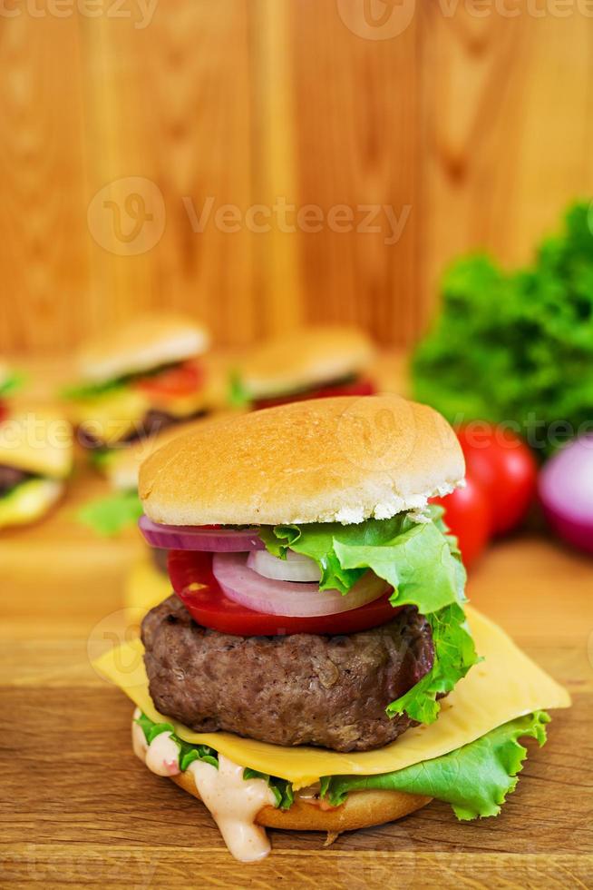 deliciosa hamburguesa hecha a mano sobre fondo de madera foto