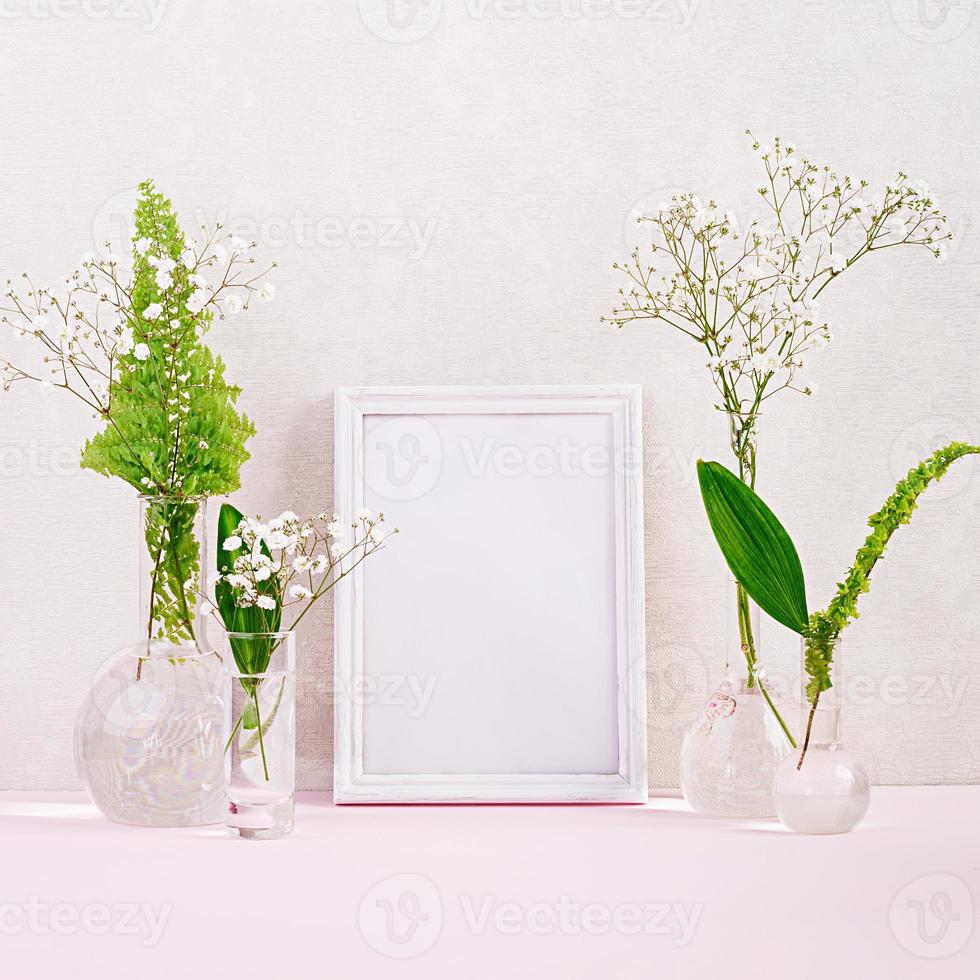 Flowers and plants in flask with frame. Beautiful spring background with flowers in vase. photo
