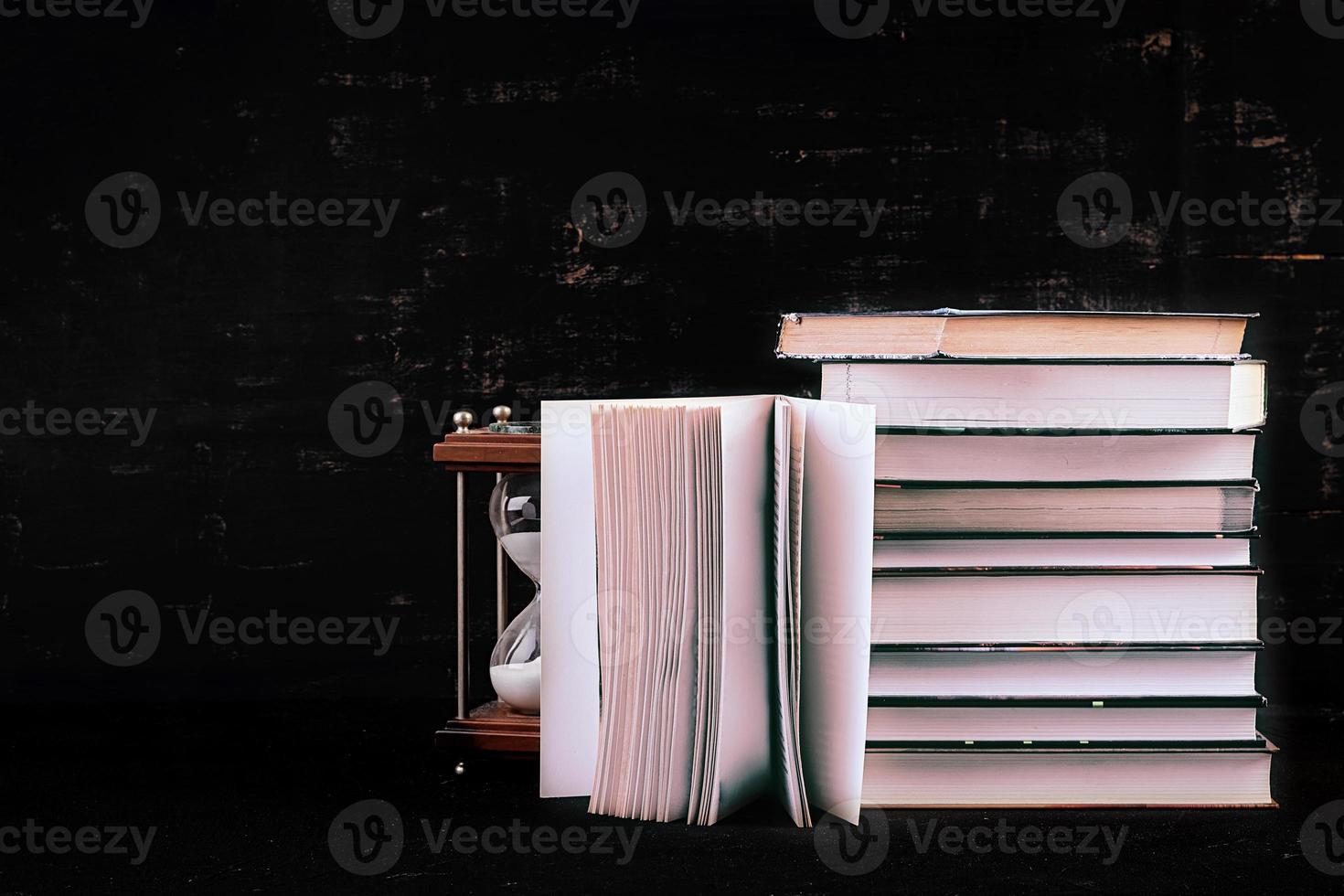 Stack of different books on dark background. Knowledge concept. photo