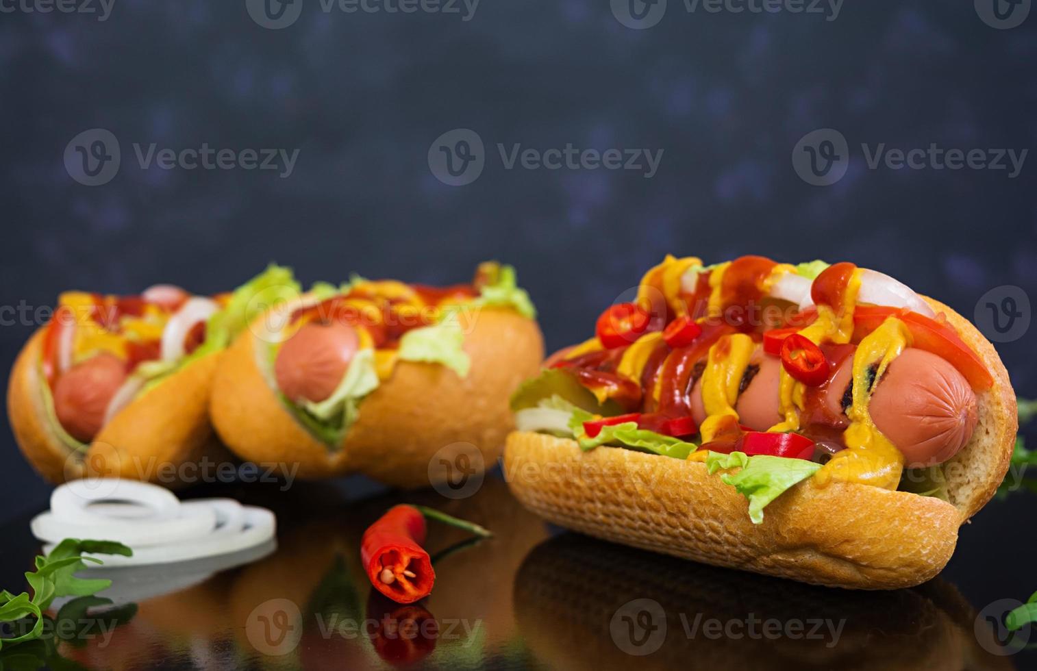 Delicious homemade hot dog on dark background photo