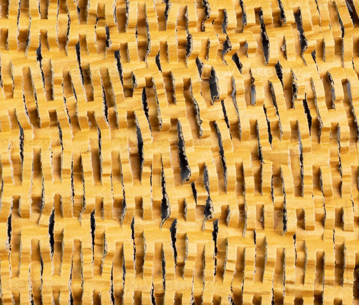 The surface of the cardboard that is intended to be cut into strips to create flexibility from the thickness making it reused for other uses such as used as cushioning material photo