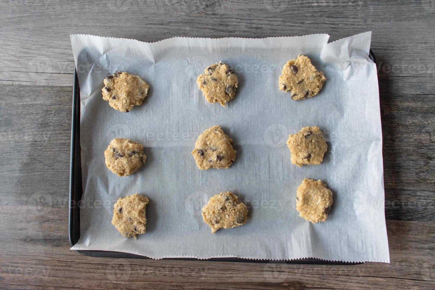 raw unbaked homemade oatmeal cookies on baking sheet flat lay photo