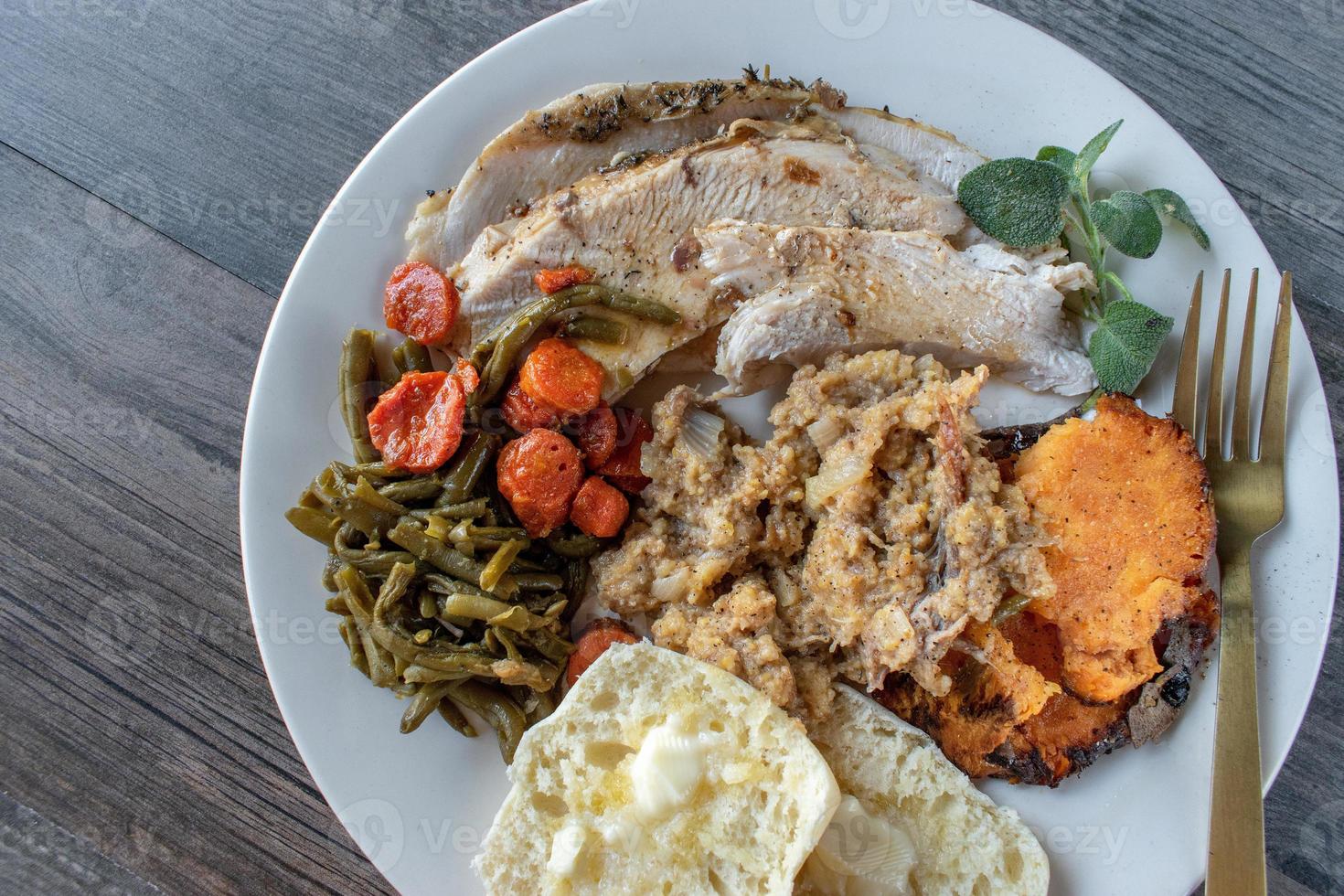 Plated roasted turkey, stuffing, and sides flat lay photo