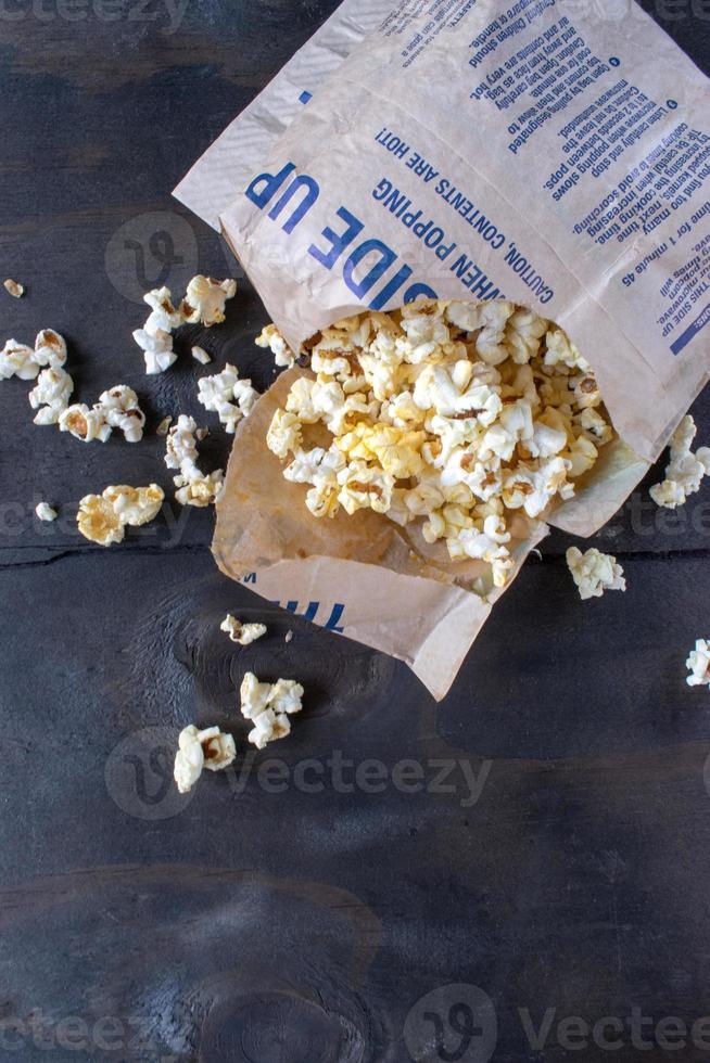 popped bag popcorn torn open and spilling out flat lay photo