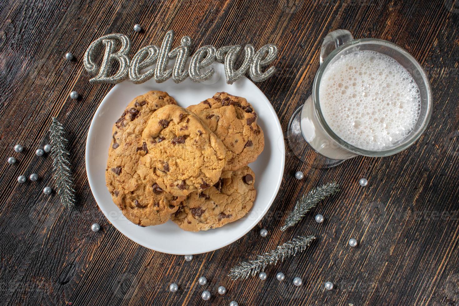 Milk and cookies for Christmas Santa Claus with silver believe message flat lay photo