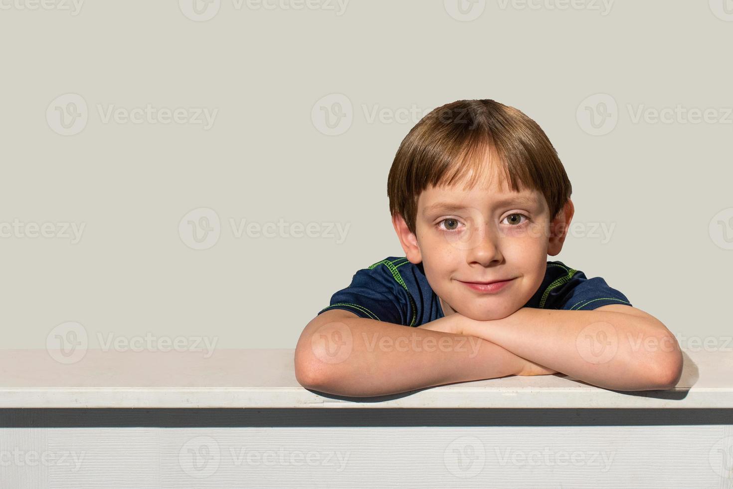 smiling happy young boy with brown eyes on frame edge with copy space photo