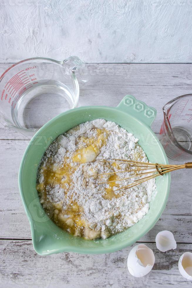 Ingredients for baking a cake around a bright bowl flat lay photo