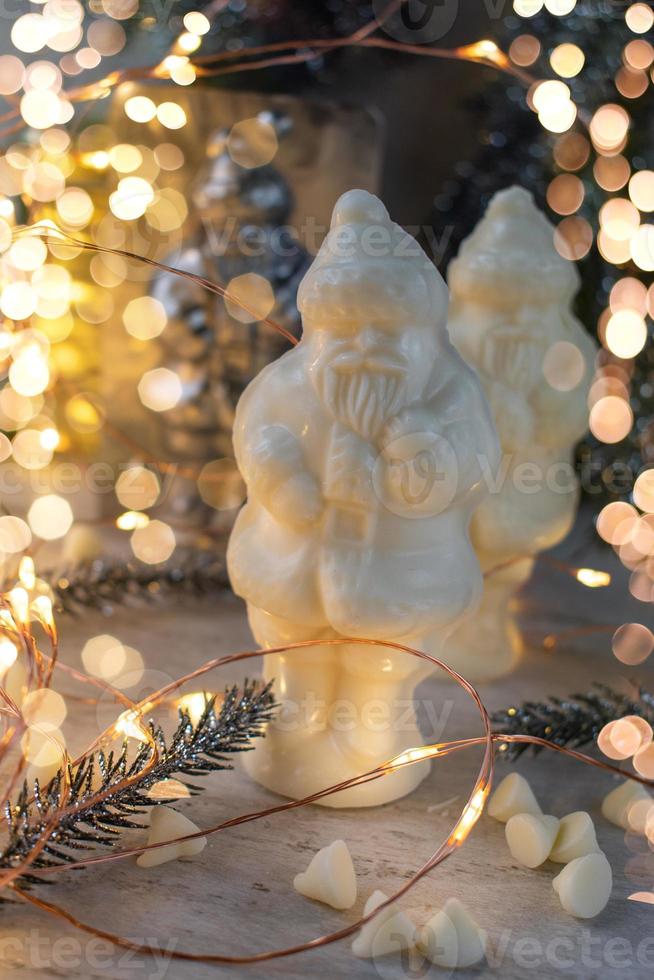 Christmas candy making molded Santa Claus in white chocolate with festive lights photo