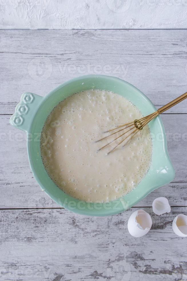 Mixing cake batter ingredients in a bright bowl flat lay photo