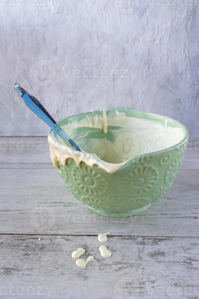 Remnants of cake batter in a bright bowl with drips flat lay photo