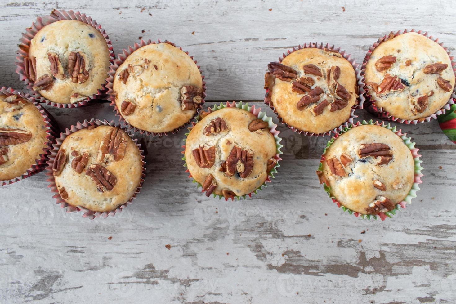 group of baked blueberry muffins topped with pecans with copy space photo
