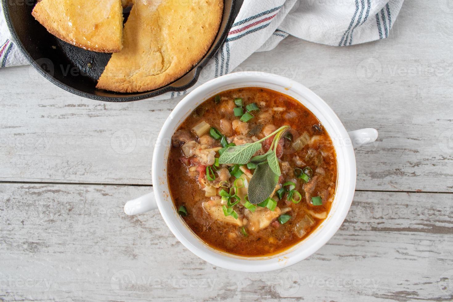 abundante sopa de verduras con zanahorias, puerros y frijoles negros en caldo de res plano foto