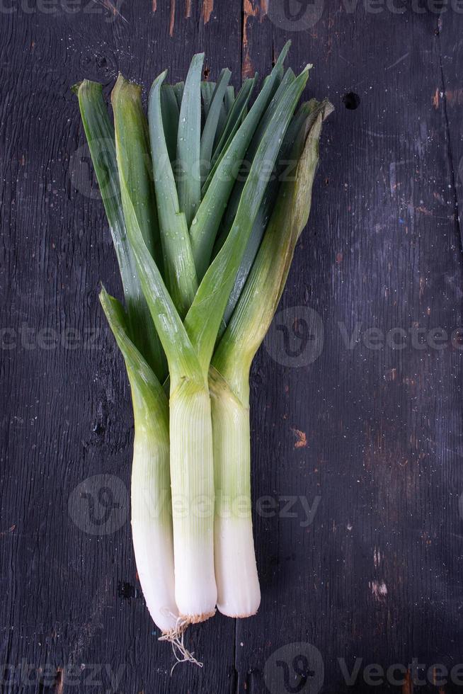 fresh vegetable leek stalks on wooden table flat lay photo