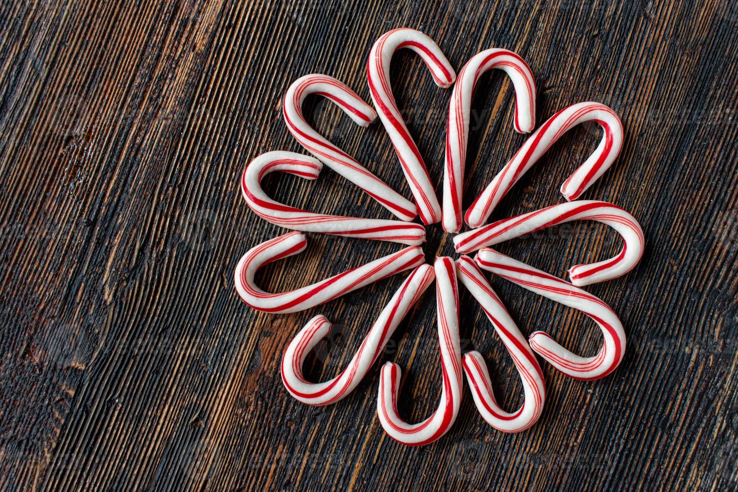 candy canes in a flower design on rustic wood table flat lay photo