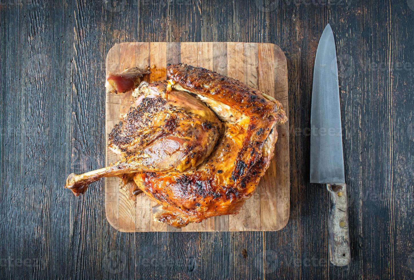 preparándose para cortar medio pavo dorado al horno en una tabla de cortar plana foto