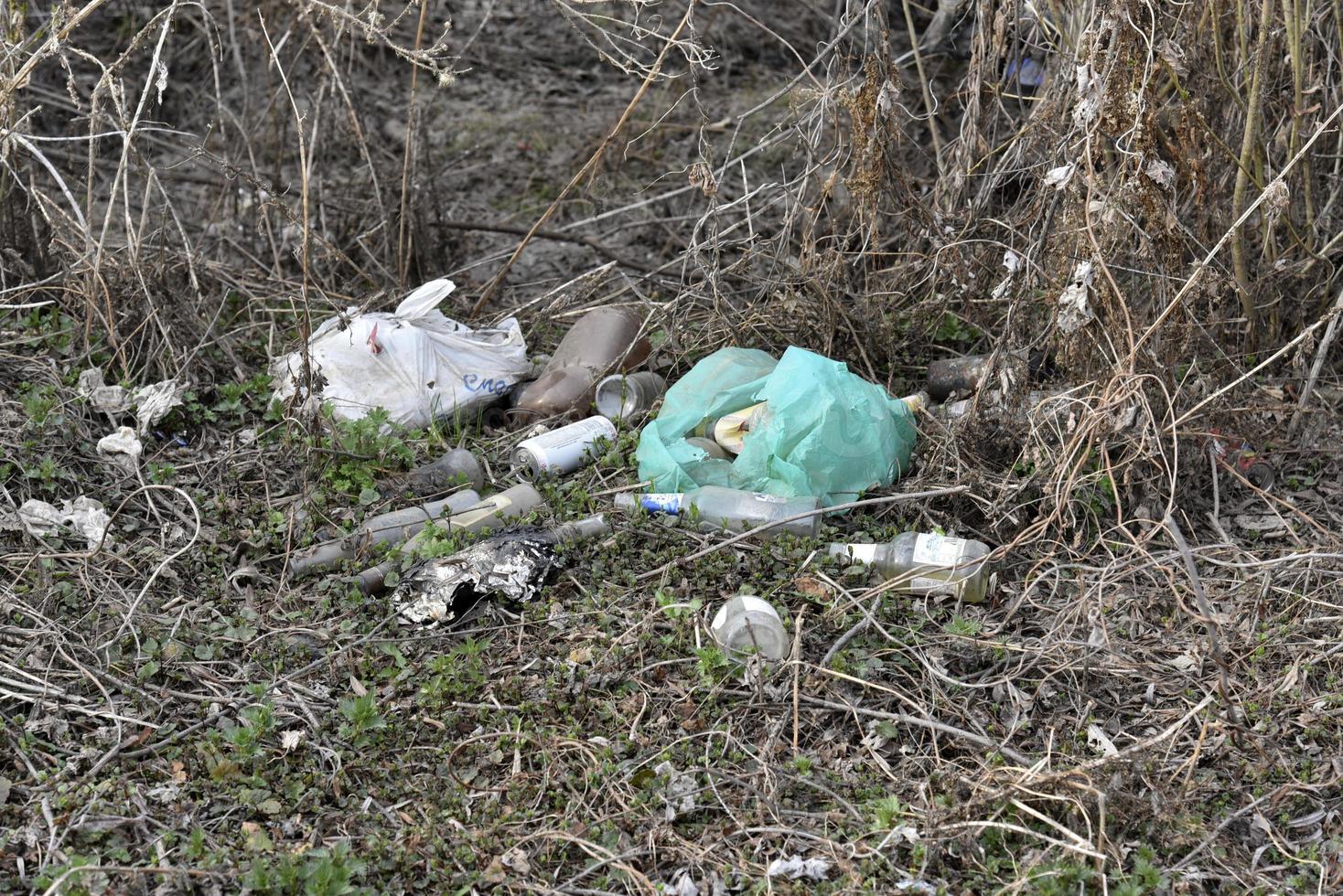 Garbage and household waste on the riverbank from vacationers. Environmental pollution. photo