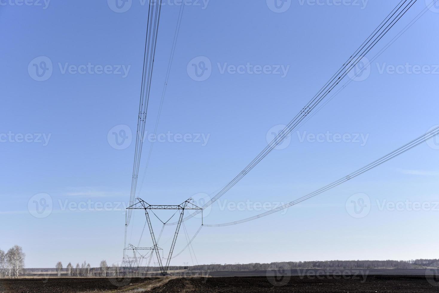 Ultra-high voltage power line in the field in spring in Russia photo