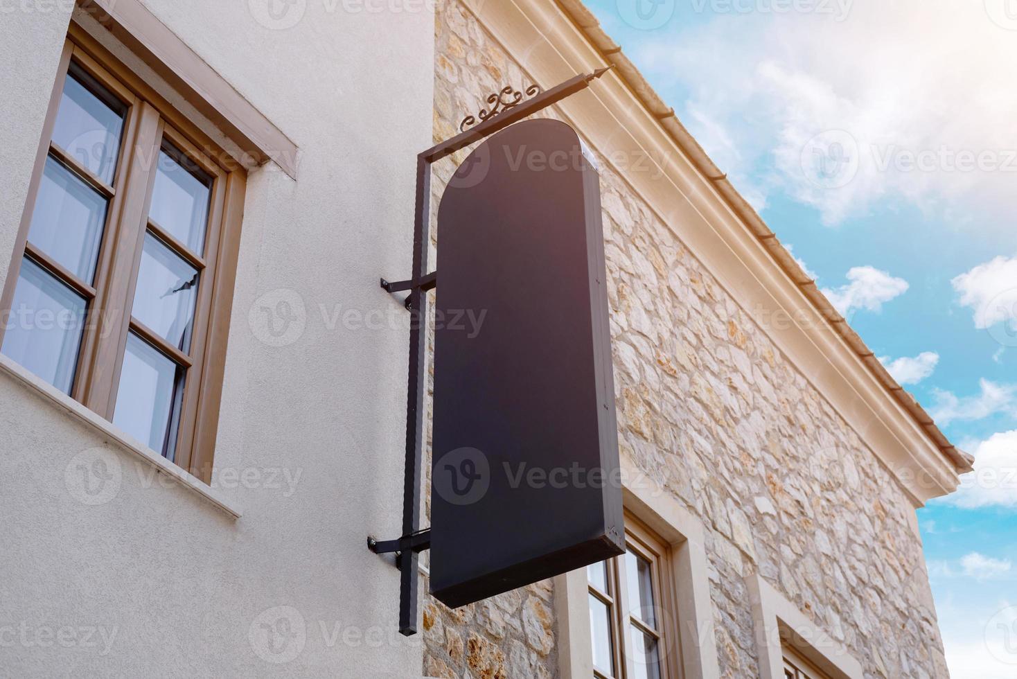 Large black vertical sign on the street facade. Mockup for promotion, branding and logo presentation photo