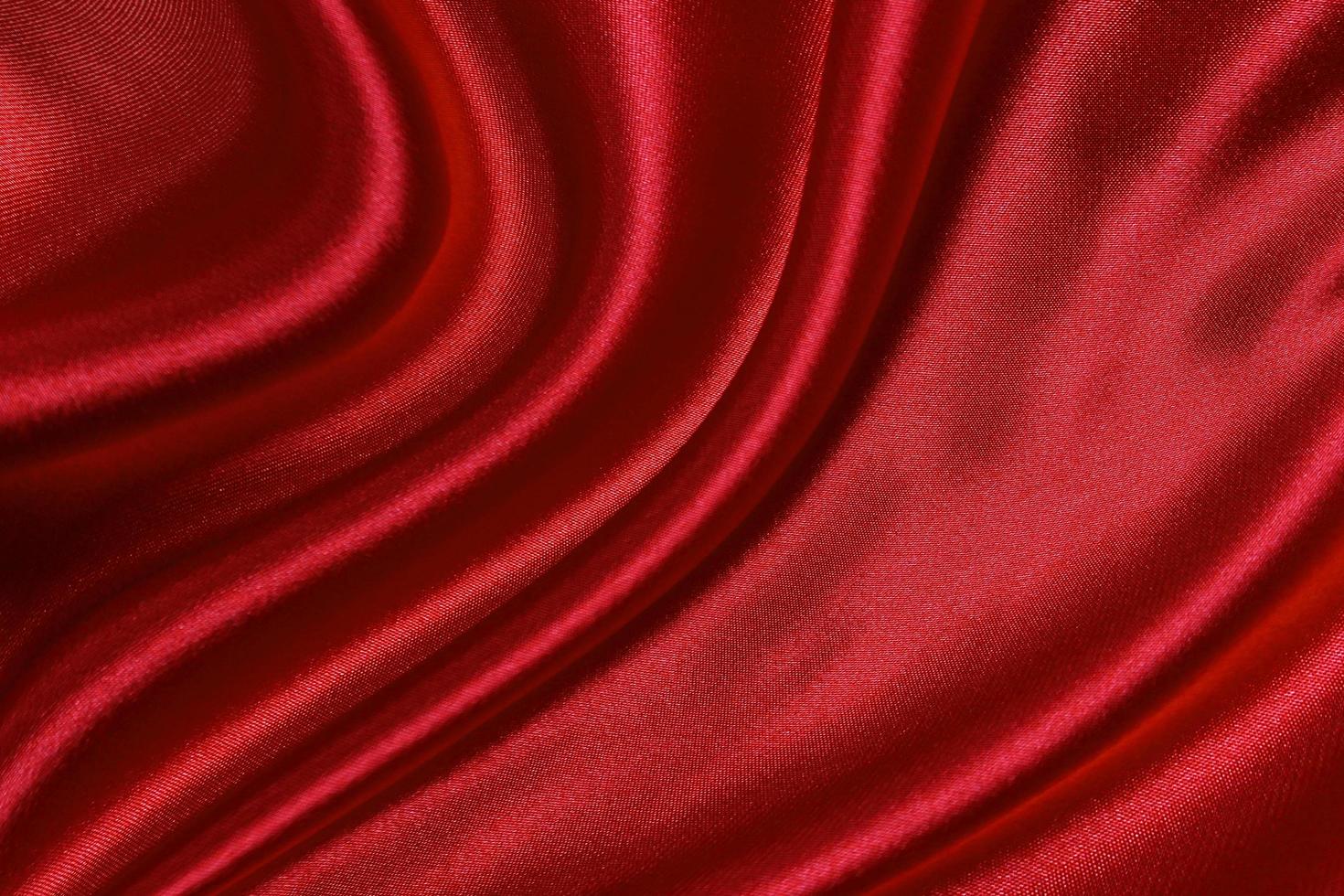 La textura de seda roja o tela satinada de lujo puede usarse como fondo abstracto. vista superior foto