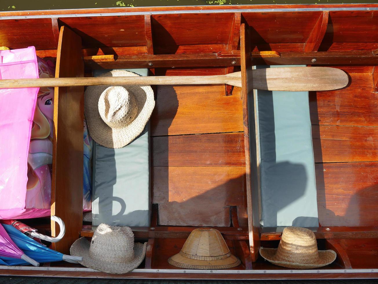 close up top view of floating wooden boat in thailand with vintage hats photo