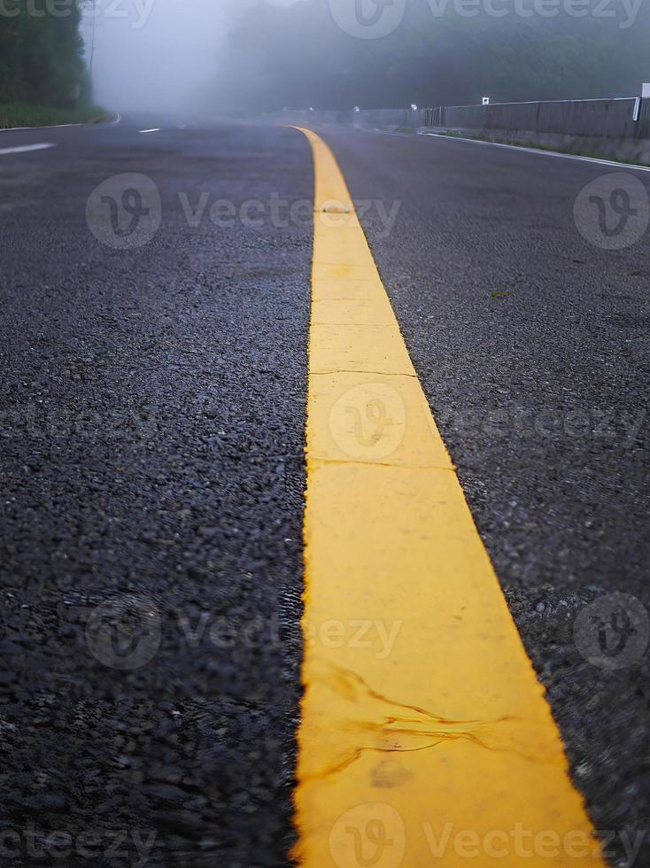 yellow stripe line painted on the asphalt road for traffic sign photo