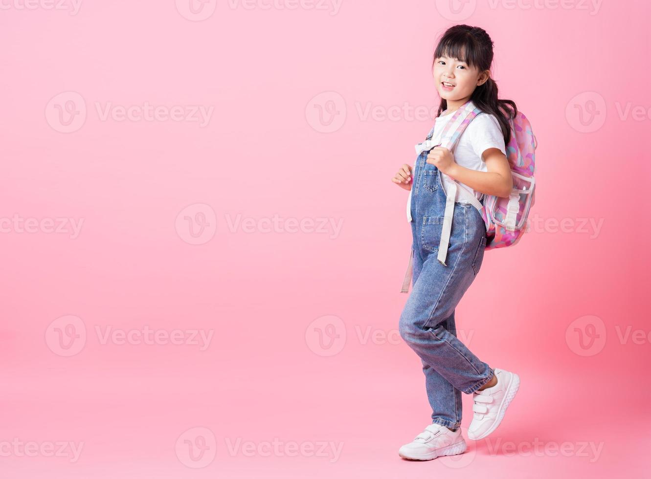 Image of Asian primary school student on pink background photo