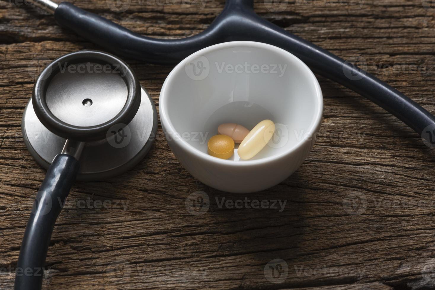 Pills in a container and stethoscope photo