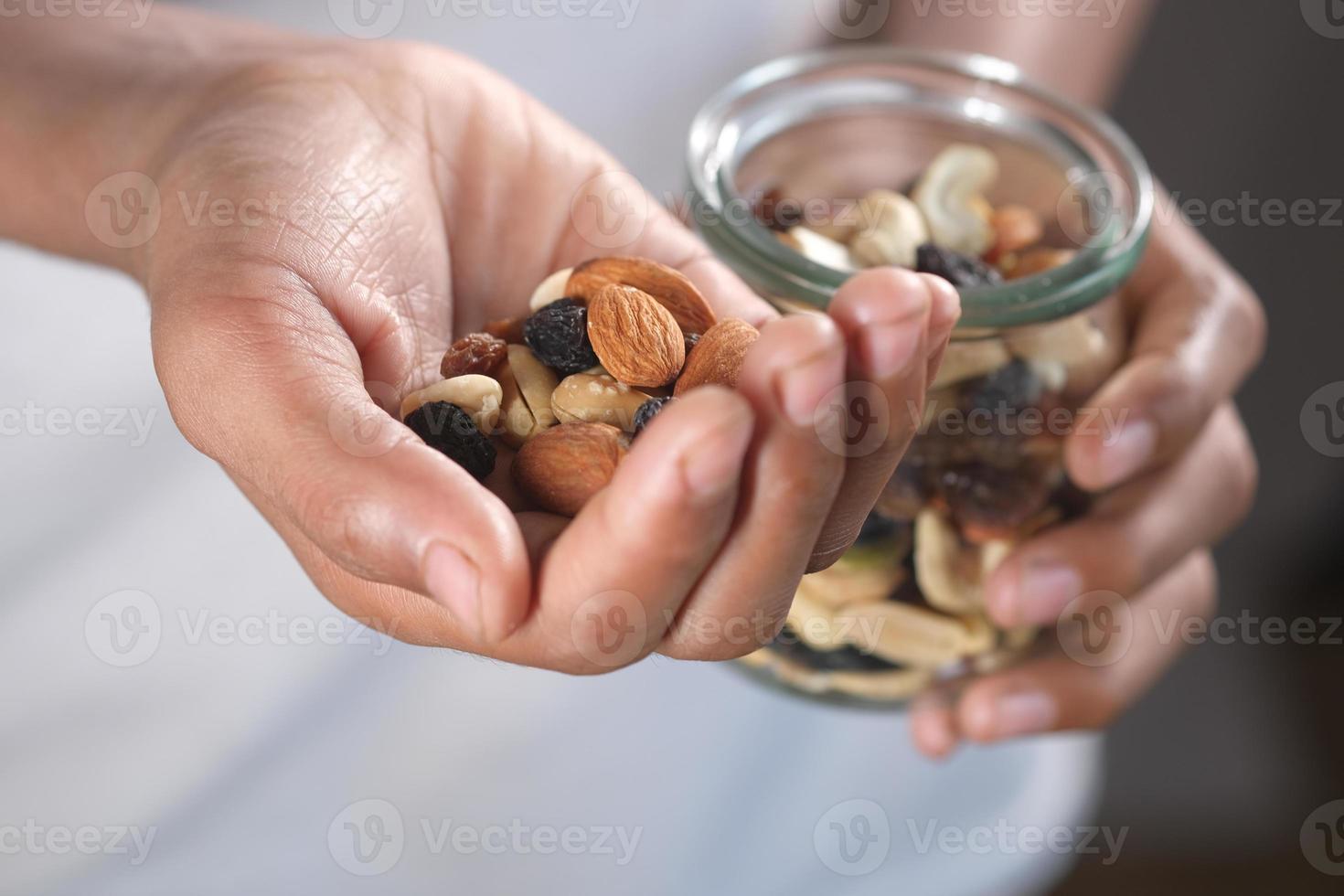 hombres jóvenes comiendo nueces mixtas foto