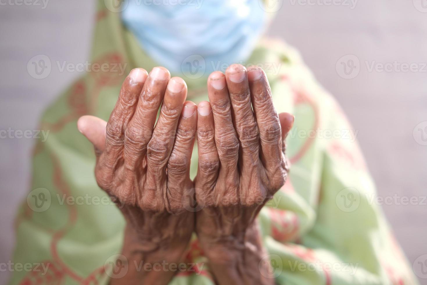 senior women with face mask hand praying at ramadan photo