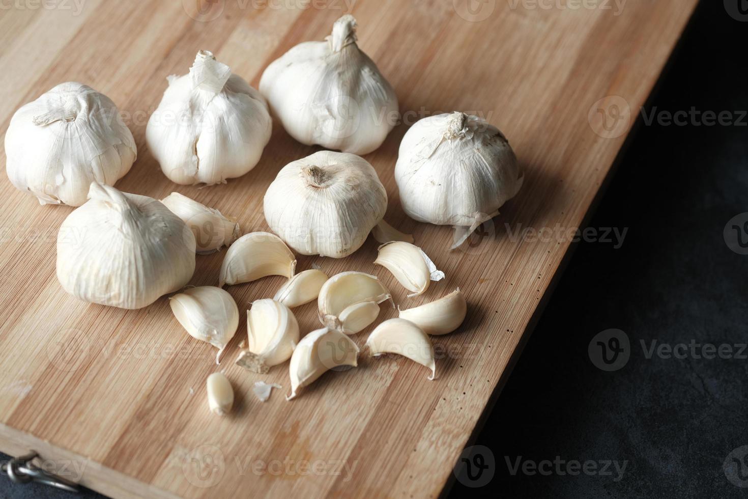 garlic on a chopping board on table photo