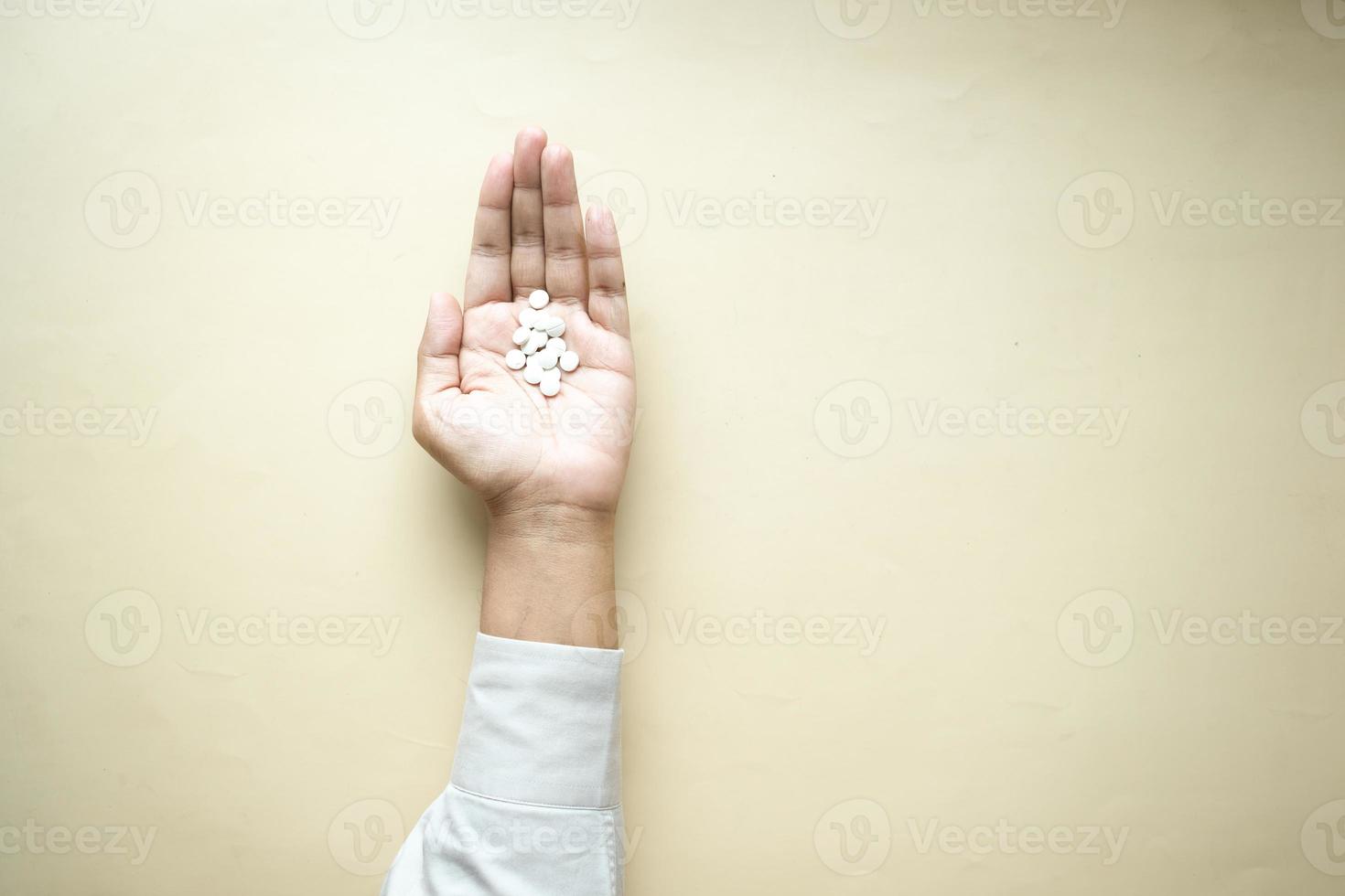 top view of medical pills on palm of hand on table photo