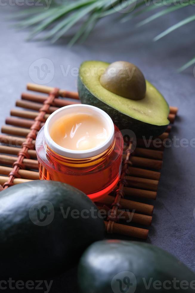 Close up of beauty cream and avocado on table photo