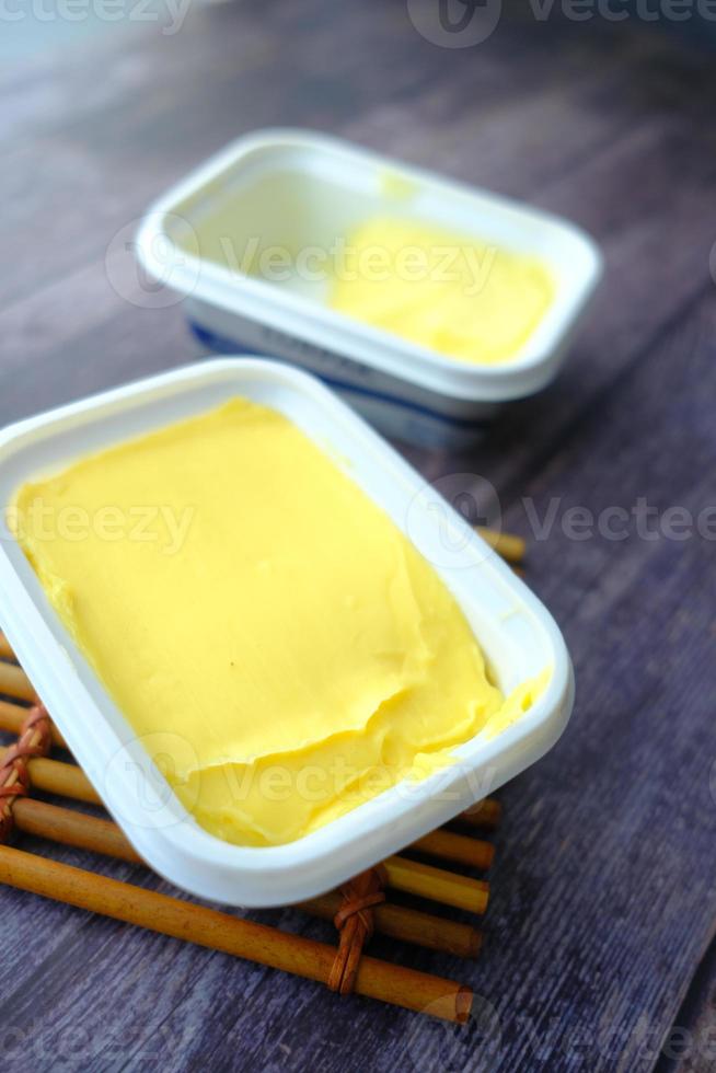 fresh butter in a container with bread on white background photo