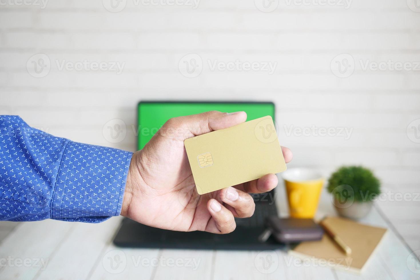 hombre en traje casual mostrando tarjeta de crédito foto