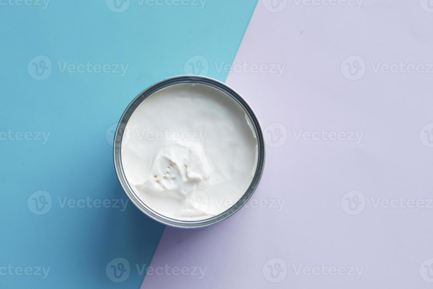top view of milk cream in a container on blue background, 7612481 Stock
