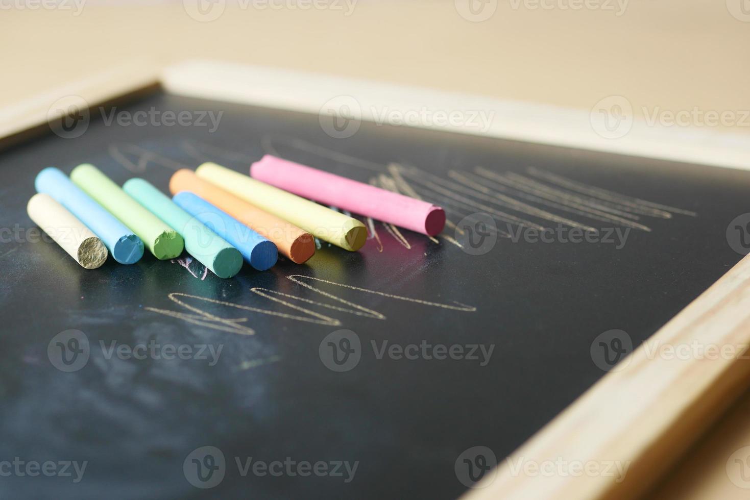 colorful chalk and chalkboard on black background photo