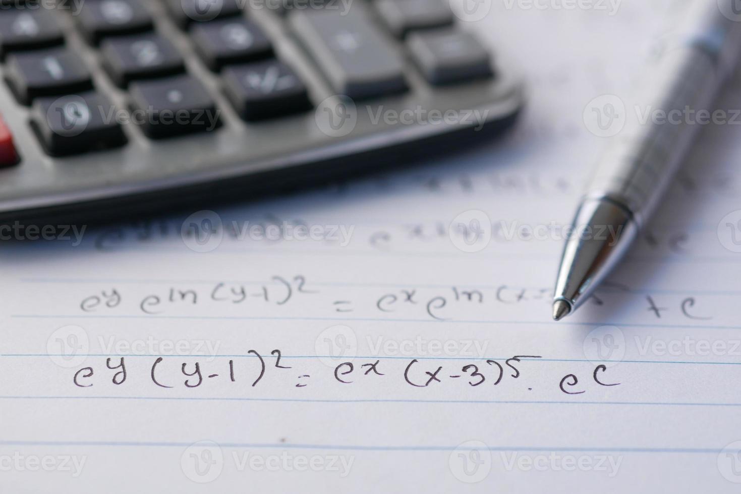 Hand writing algebra equations on a paper photo
