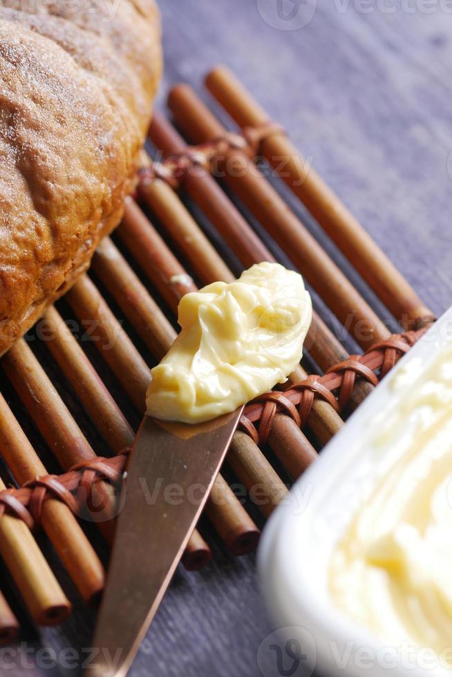 rebanada de mantequilla con pan en la mesa foto