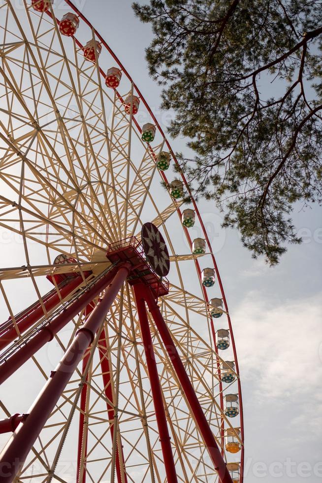 Round ferris wheel spins fast at colorful day photo