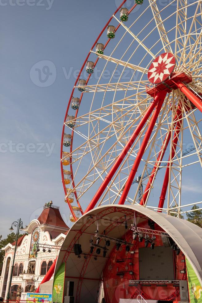 Round ferris wheel spins fast at colorful day photo