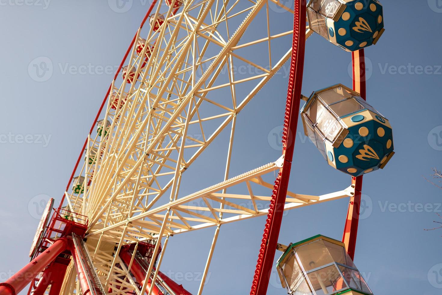 Round ferris wheel spins fast at colorful day photo