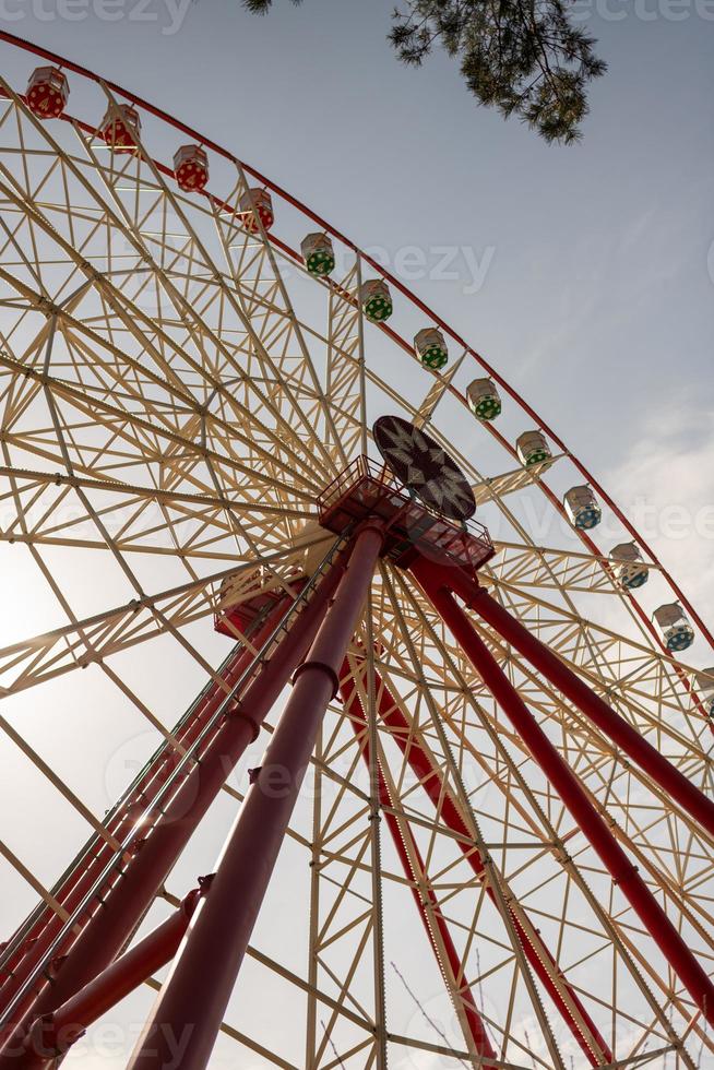 Round ferris wheel spins fast at colorful day photo