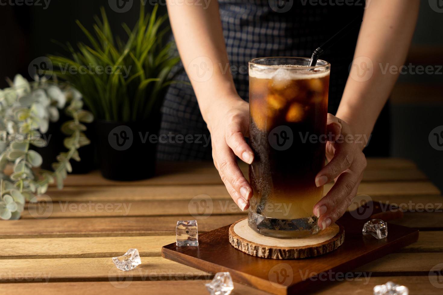 Glass of espresso with lemon juice on wooden table and copy space, Summer Cocktail, Cold brew coffee or black tea. photo