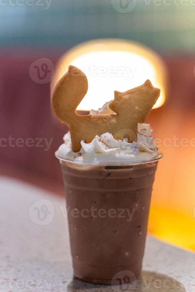 iced chocolate topped with whipped cream and crackers shaped fox at cafe photo